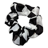 skakternet scrunchie med store skaktern placeret på en hvid baggrund. Moderigtig skakpåklædning